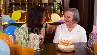 女儿和高年级妈妈在生日<strong>蛋糕</strong>或<strong>母亲节</strong>聚会上吹蜡烛
